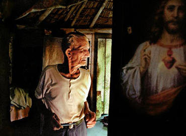 Ernesto Bazan, Man and Christ, Viñales, Cuba, 2003, 50x74 cm, stampa a colori cromogenica © Ernesto Bazan