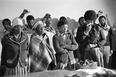 Gille de Vlieg, Pauline Moloise (madre di Ben), due donne e Winnie Madikizela Mandela piangono al servizio funebre per Benjamin Moloise, impiccato qualche ora prima di quella stessa mattina. Khotso House, Johannesburg, 18 ottobre  1985. © Gille de Vlieg.